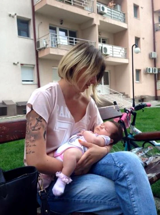 Alina Plugaru (27 de ani) ține un bebeluș în brațe