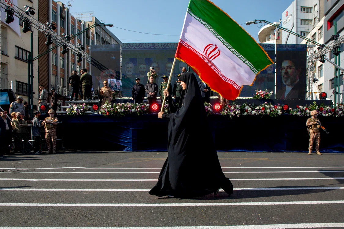 O femeie poartă un steag iranian în timpul unei demonstrații pro-guvernamentale. FOTO: Getty Images