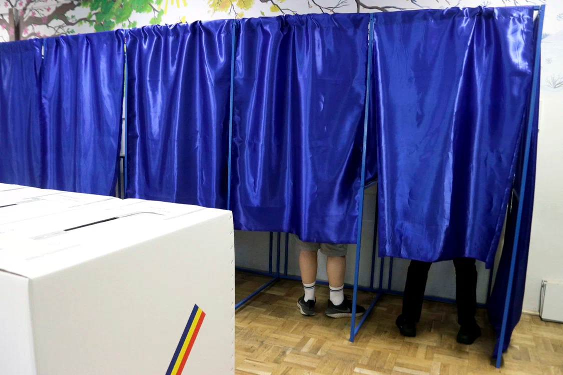 o sectie de vot cu cateva cabine in care oamenii voteaza