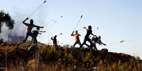 Protestatari palestinieni arunca cu pietre în soldaţii israelieni în timpul confruntărilor din Betunia în apropiere de oraşul Ramallah din West Bank foto reuters