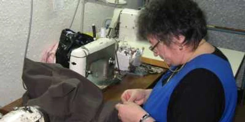 O croitoreasă lucrează la una dintre numeroasele comenzi primite de la clientele sale