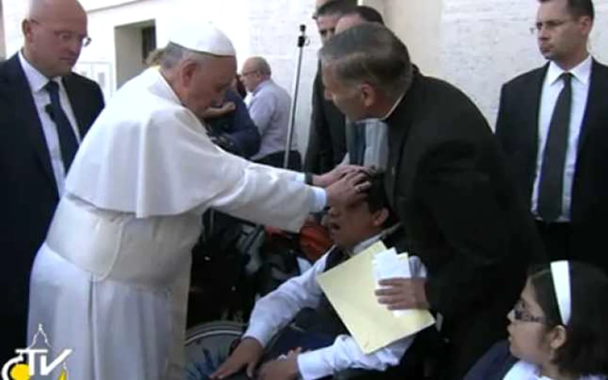 Papa Francisc şi-a întins mâinile asupra unui tânăr bolnav, în timp ce rostea o rugăciune.             FOTO: TV 2000