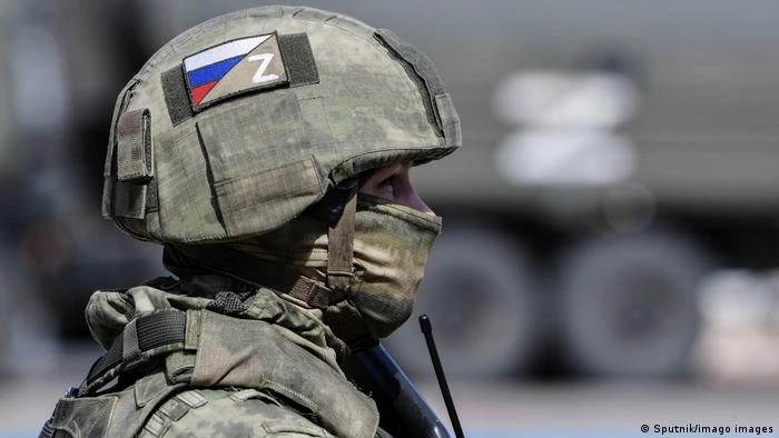 Soldat purtând o cască cu un simbol Z și un steag rusesc pe ea