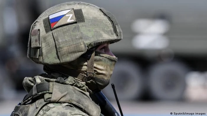 Soldat purtând o cască cu un simbol Z și un steag rusesc pe ea