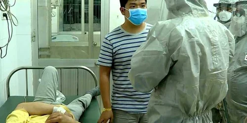 Oficiali de la Ministerul Sănătăţii din Vietnam discută cu un pacient depistat pozitiv în spitalul din oraşul Ho Chi Minh. FOTO EPA-EFE Cho Ray