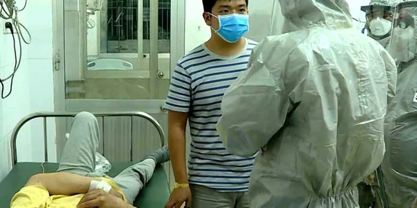 Oficiali de la Ministerul Sănătăţii din Vietnam discută cu un pacient depistat pozitiv în spitalul din oraşul Ho Chi Minh. FOTO EPA-EFE Cho Ray