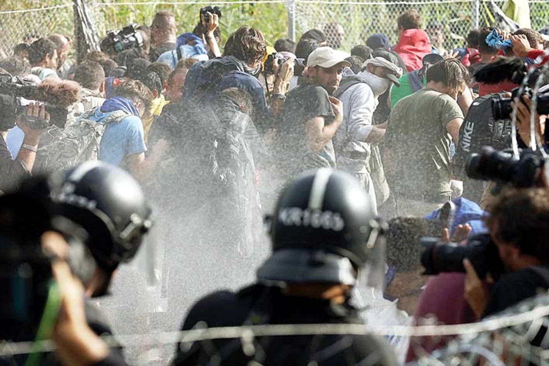 
    Poliţiştii i-au respins pe imigranţi cu gaze lacrimogene şi jeturi de apăFotografii: AFP/GettyImages  