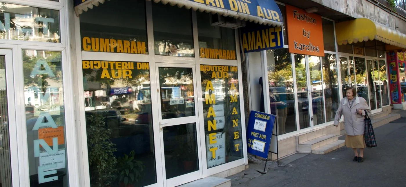 casă de amanet prin fața căreia trece o doamnă