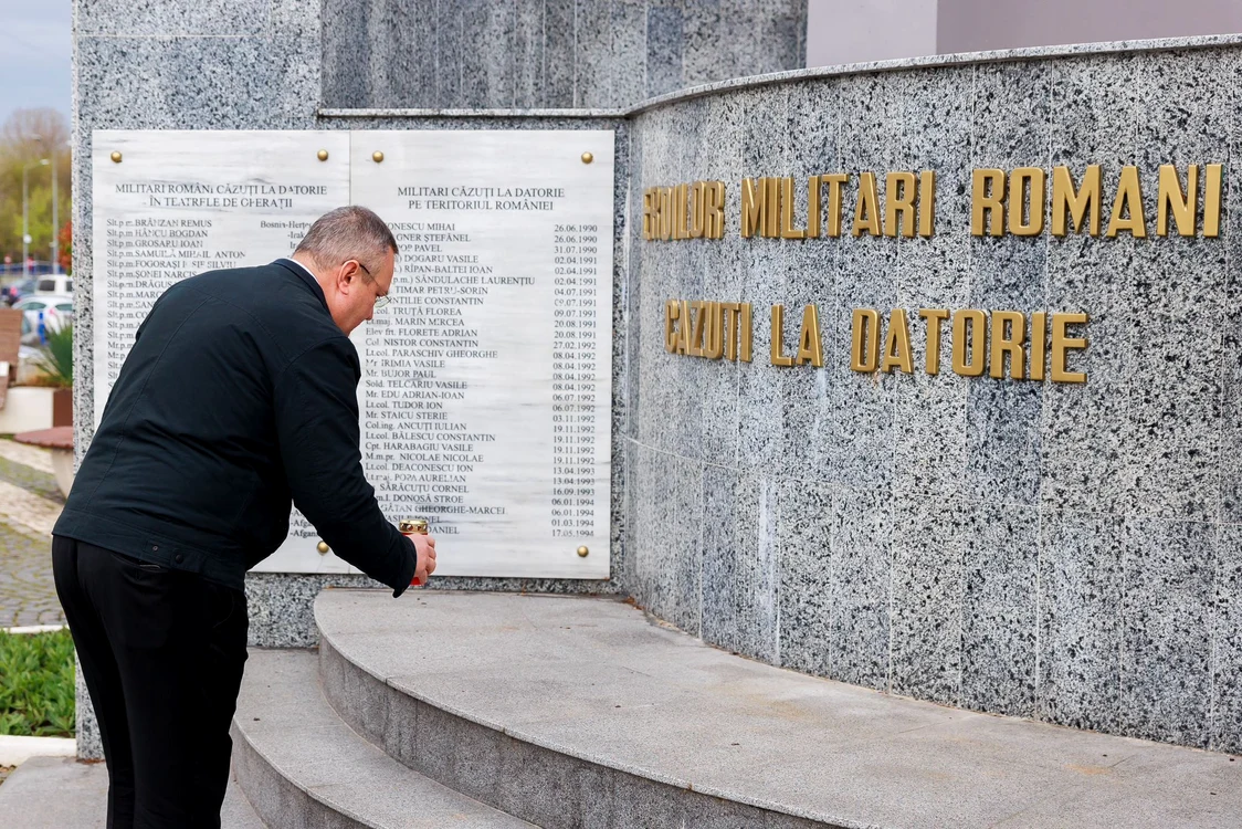 Nicolae Ciucă aprinzând o lumânare pentru militarii români FOTO gov.ro