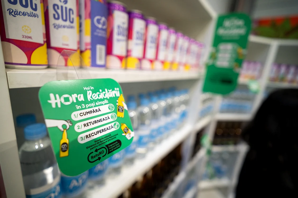 Afiș pe un raft, pe care scrie Hora Reciclării