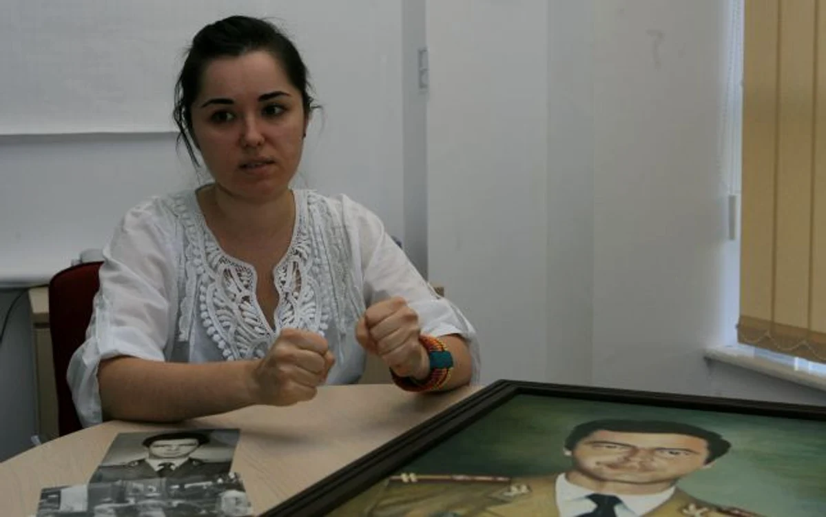 Anca, fiica maiorului Adrian Barbu, se uită cu lacrimi în ochi la tabloul tatălui său