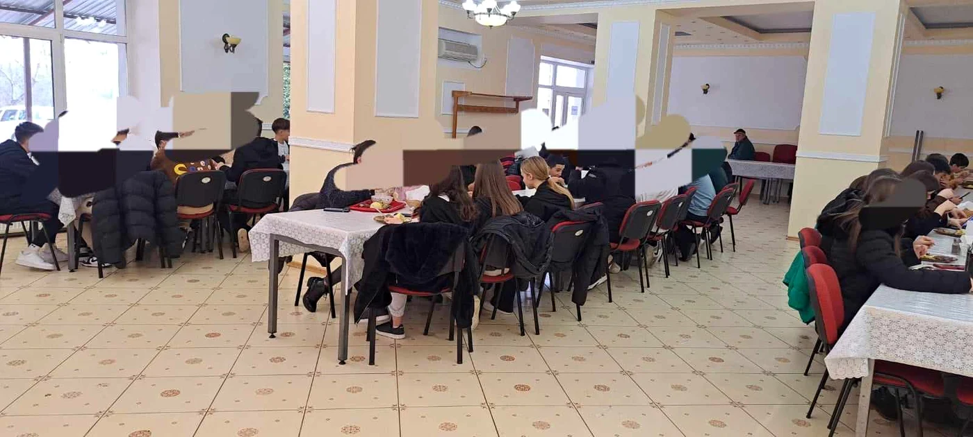 școlari care servesc masa într-o cantină