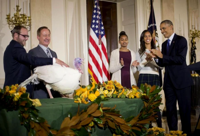 Preşedintele Barack Obama şi cele două fiice ale sale, Sasha şi Malia, în timpul ceremoniei de graţiere a curcanilor FOTO AP