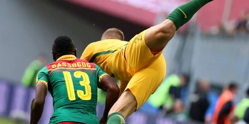 Christian Bassogog(Camerun) şi Alex Gersbach (Australia) se luptă pentru balon în timpul partidei din grupa B de la Cupa Confederaţiilor 2017. FOTO EPA