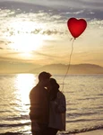 couple with heart balloon hugging sea shore evening jpg