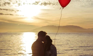 couple with heart balloon hugging sea shore evening jpg