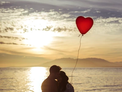 couple with heart balloon hugging sea shore evening jpg