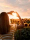 back view woman making heart shaped hands sunset jpg