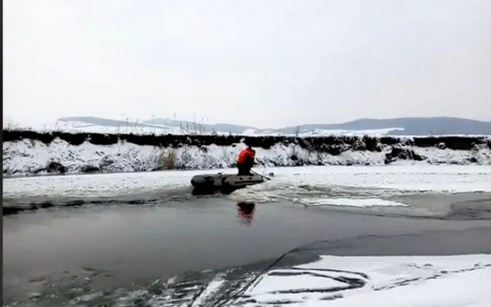 Pompierii s-au deplasat cu o barcă spre căţelul prins între sloiurile de gheaţă. FOTO: captură video ISU Cluj