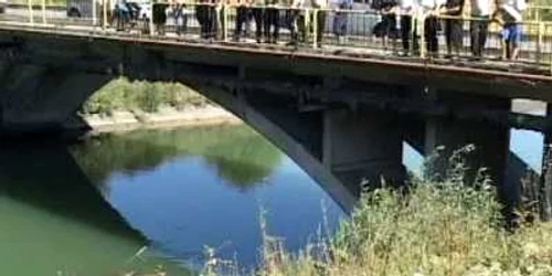 Oamenii s-au strâns pe marginea podului să vadă mașina care a ajuns în canal