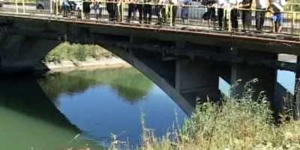 Oamenii s-au strâns pe marginea podului să vadă mașina care a ajuns în canal