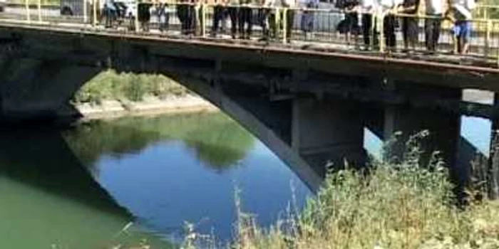 Oamenii s-au strâns pe marginea podului să vadă mașina care a ajuns în canal