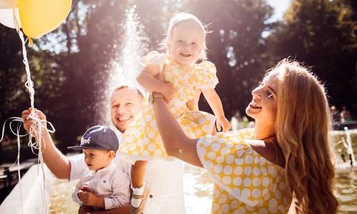 lovely family dressed same clothes sits fountain with their children yellow balloons jpg
