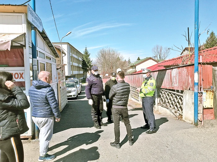 Poliţişti locali  cu măşti păzesc  intrarea 