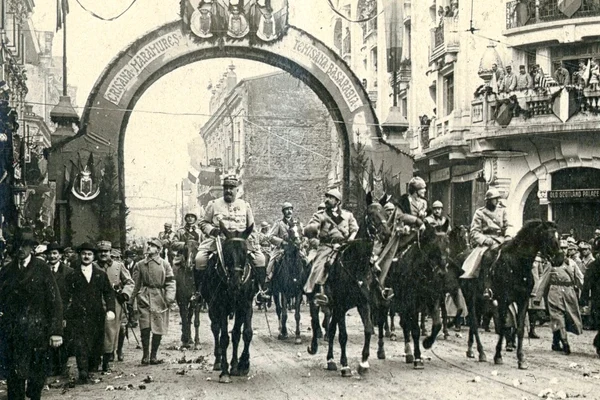 Trecerea familiei regale și a generalului Berthelot pe sub Arcul de Triumf ridicat pe Calea Victoriei, la intrarea în Piața Palatului Regal, la 18 Noiembrie/1 Decembrie 1918