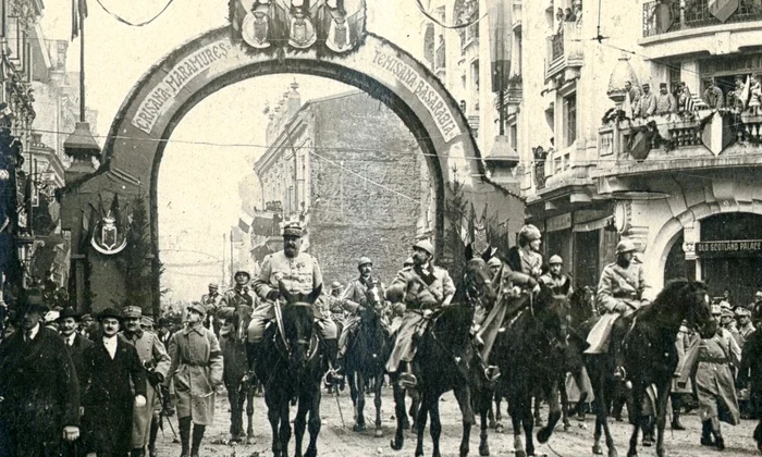 Trecerea familiei regale și a generalului Berthelot pe sub Arcul de Triumf ridicat pe Calea Victoriei, la intrarea în Piața Palatului Regal, la 18 Noiembrie/1 Decembrie 1918