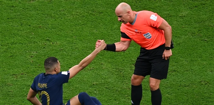 Szymon Marciniak îl ajută pe Mbappe să se ridice după finala Cupei Mondiale. Foto EPA EFE