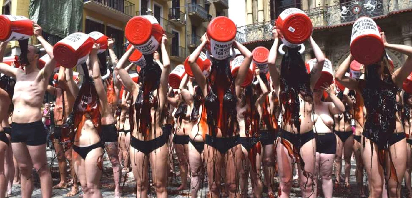 Protestatarii varsă pe ei găleţile pline cu lichid asemănător sângelui în semn de revoltă pentru luptele cu tauri de la Pamplona Foto peta.org.uk