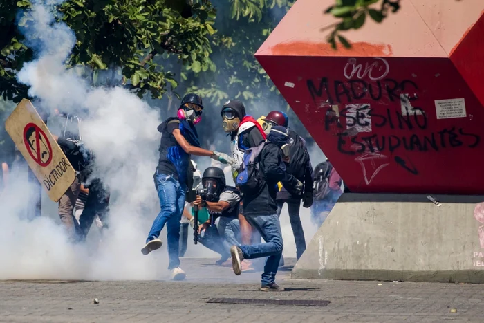 Protestatari se confruntă cu poliţia în timpul unei demonstraţii a opoziţiei la Caracas Venezuela FOTO EPA / Miguel Gutierrez