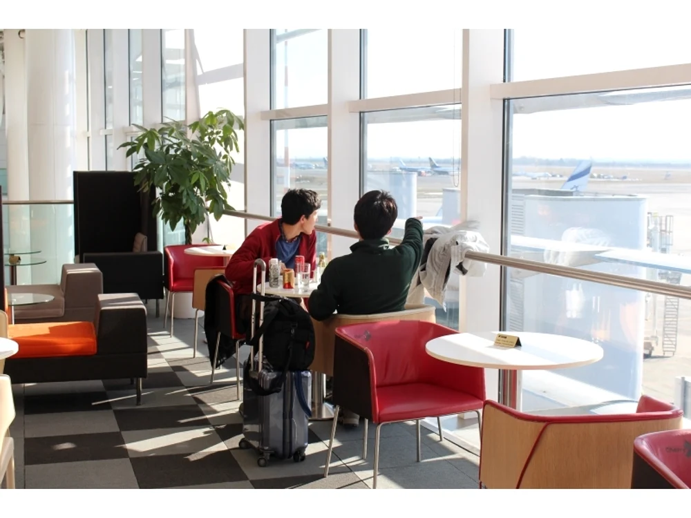 Doi tineri stau la o masă din Aeroportul Otopeni