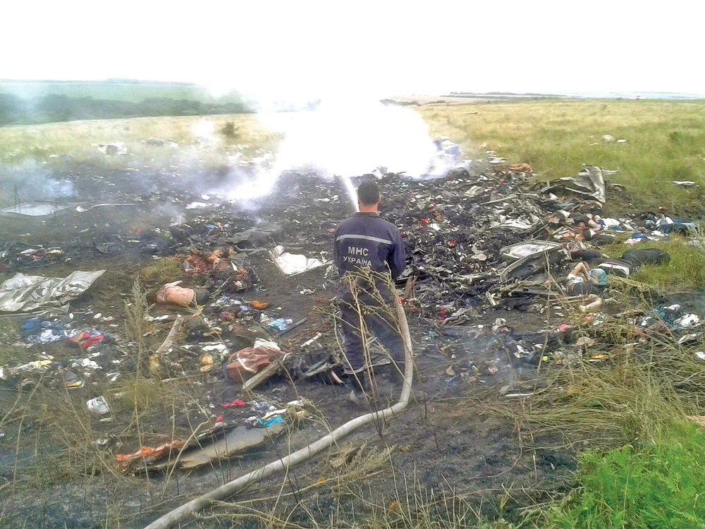 
    Un pompier stinge flăcările care au mistuit avionul. În jurul lui sunt zeci de cadavreFoto: Reuters  