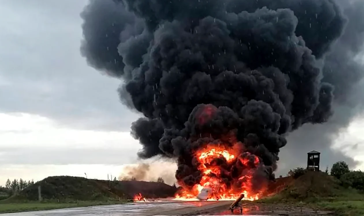 Avion militar în flăcări, înconjurat de fum negru