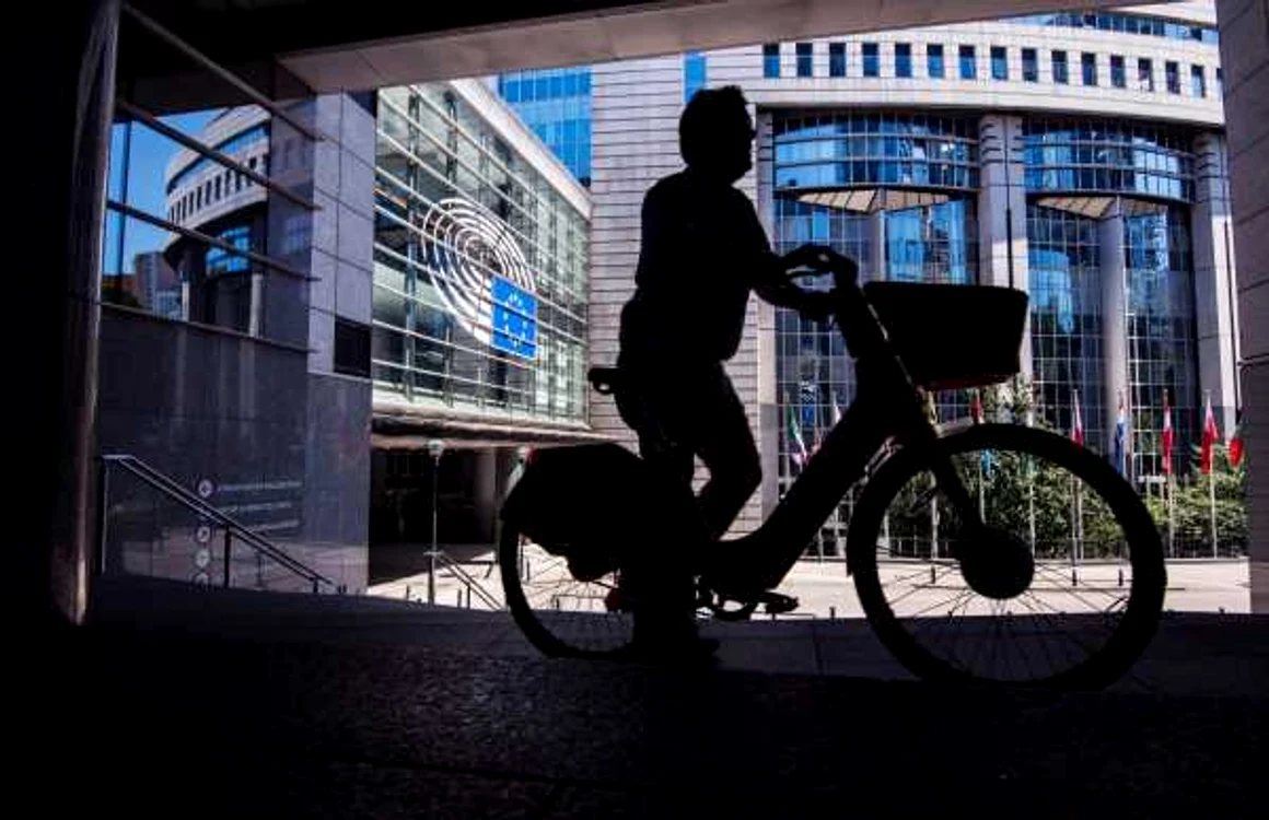 Bărbat pe bicicletă în faţa sediului Parlamentului European din Bruxelles FOTO SHUTTERSTOCK