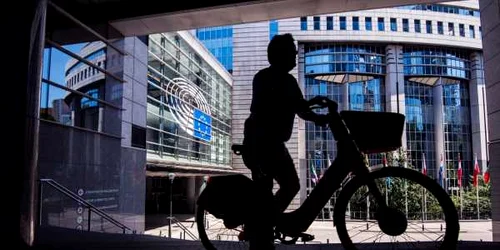 Bărbat pe bicicletă în faţa sediului Parlamentului European din Bruxelles FOTO SHUTTERSTOCK