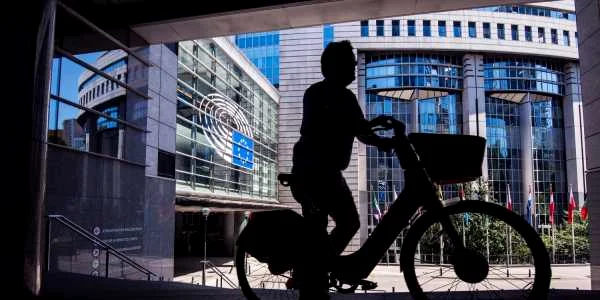 Bărbat pe bicicletă în faţa sediului Parlamentului European din Bruxelles FOTO SHUTTERSTOCK