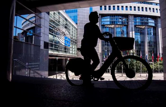 Bărbat pe bicicletă în faţa sediului Parlamentului European din Bruxelles FOTO SHUTTERSTOCK