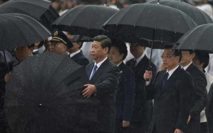 Preşedintele chinez Xi Jinping (centru), deschizându-şi umbrela. FOTO: Reuters