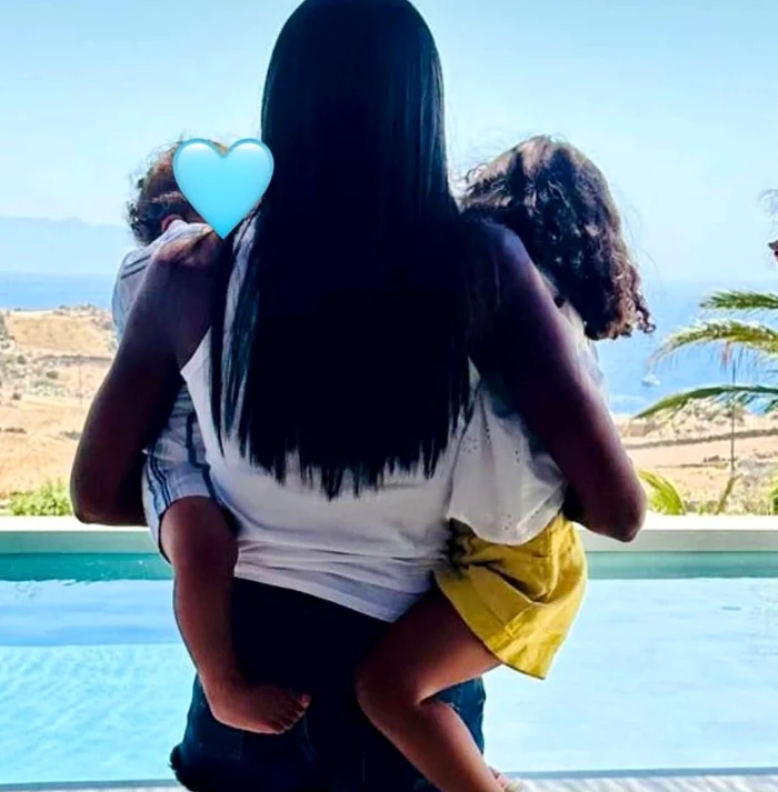 Naomi Campbell, pozată cu spatele avându-i în brațe pe cei doi copii ai ei