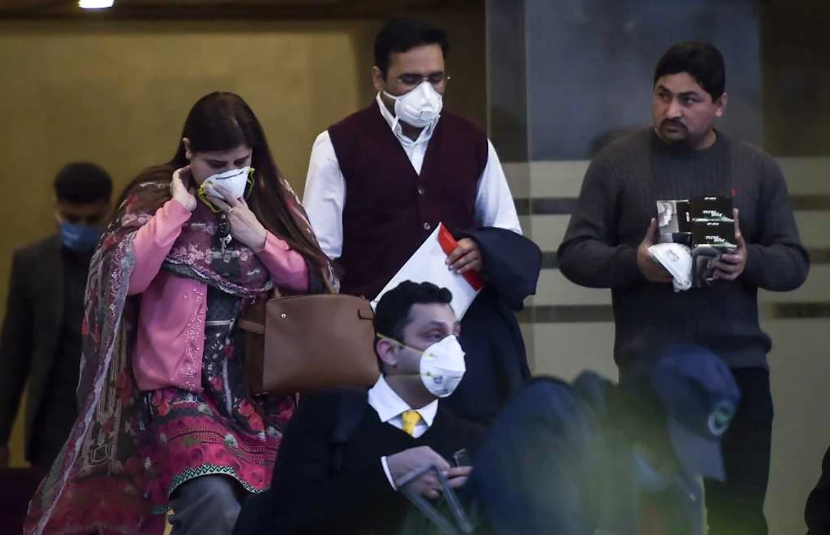Oameni cu măşti de protecţie ies dintr-o companie chinezească din Islamabad  FOTO AFP