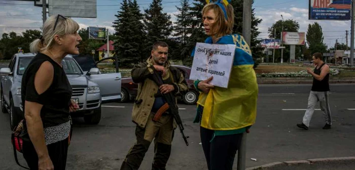 Irina Dovhan, femeia considerată spion ucrainean, a fost înfăşurată în steagul Ucrainei, scuipată şi lovită de trecători FOTO The New York Times