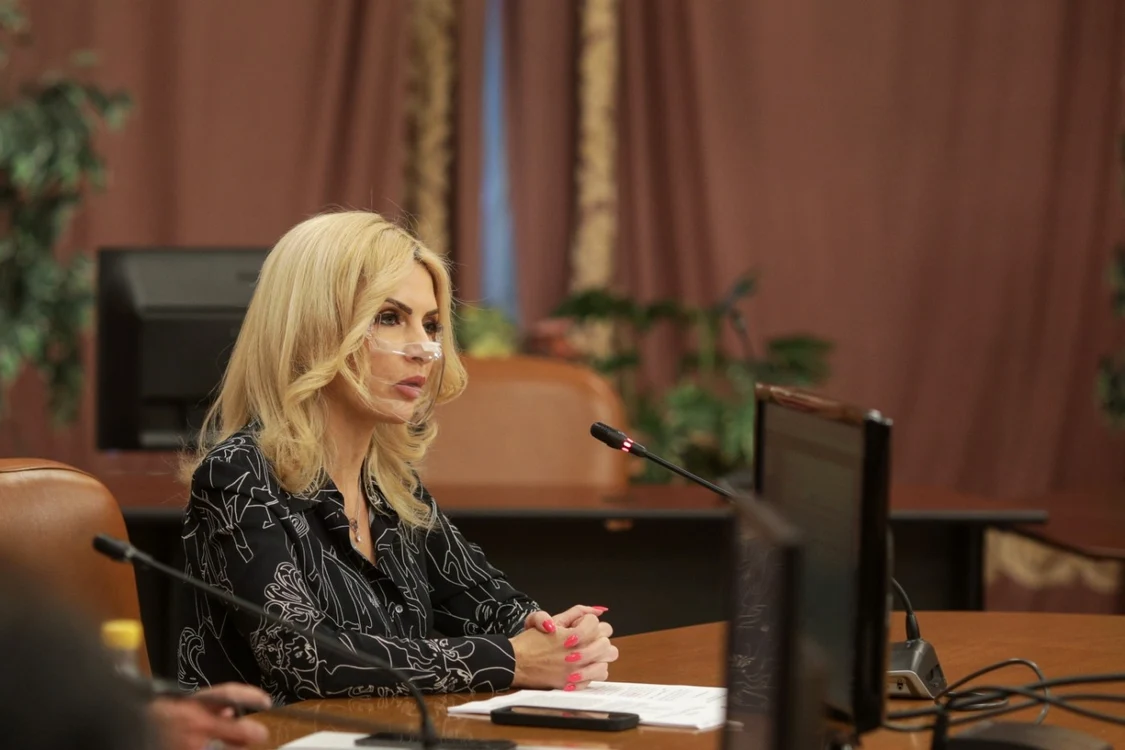 Laura Vicol vorbind la microfon în timp ce stă la birou