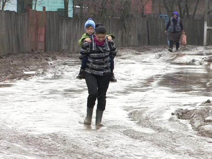 Aşa îşi duc localnicii copiii la grădiniţă din cauza nămolului FOTO Corina Macavei