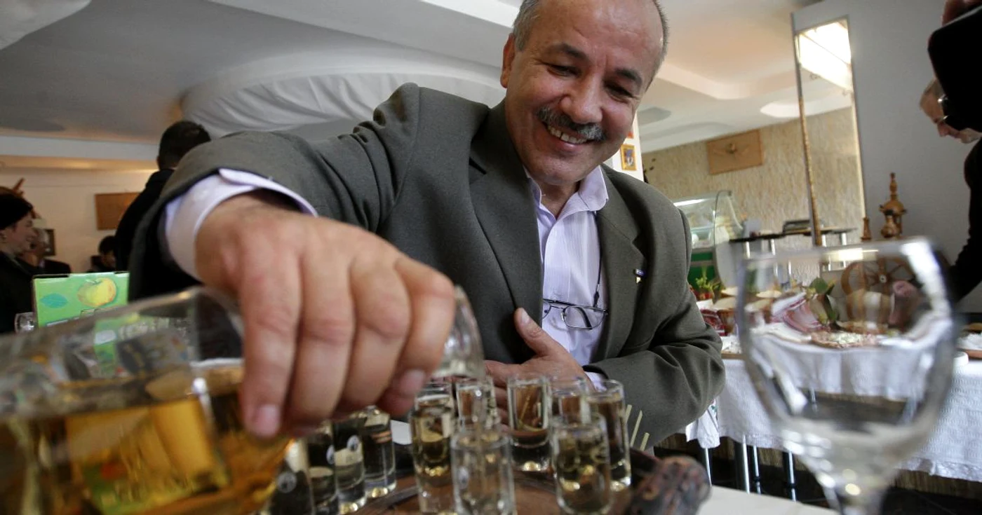 Silviu Zetea toarnă în pahare ţuica ce îi poartă numele