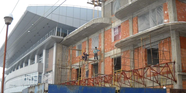 Constructorii finalizează lucrările la faţada clădirii