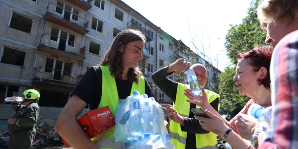 Voluntari distribuie apă localnicilor din Kiev afectați de bombardamente 