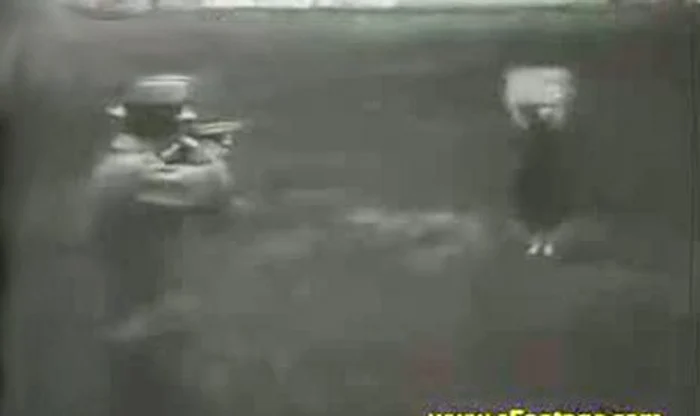 Inventatorul trage cu puşca spre soţia